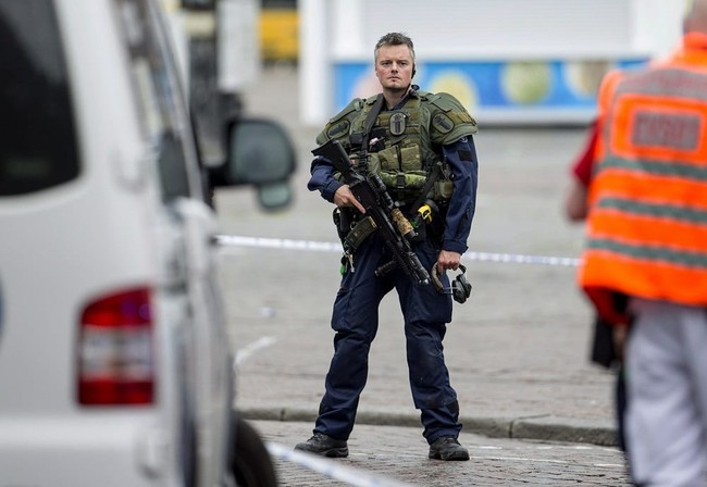 An armed police officer secures the area following a multiple stabbing attack on the Market Square in Turku, Finland, Friday Aug. 18, 2017. A man is thought to have stabbed several people in Finland's western city of Turku before police shot him in a leg and detained him, police said, adding that authorities were looking for more potential suspects. (Roni Lehti/Lehtikuva via AP)